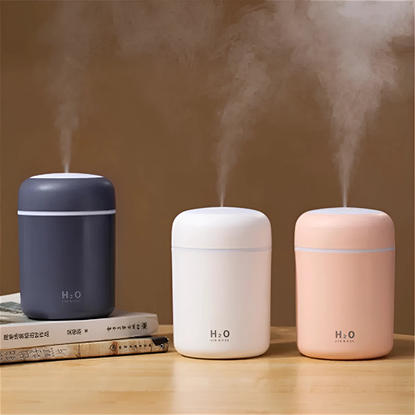 Pink car air purifying humidifier with LED lights on, next to a USB cable.