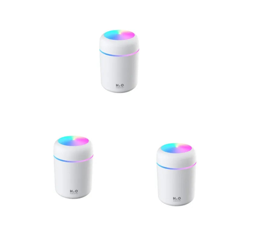 Pink car air purifying humidifier with LED lights on, next to a USB cable.