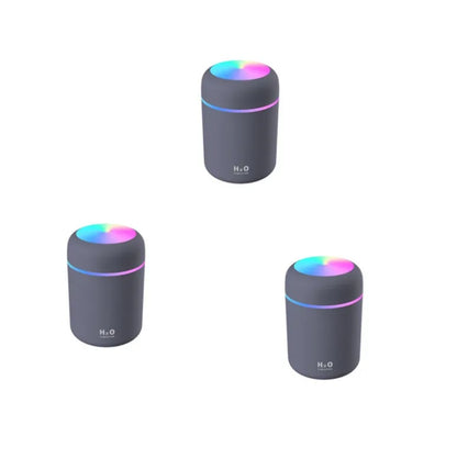 Pink car air purifying humidifier with LED lights on, next to a USB cable.