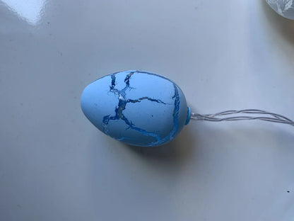 Crack egg LED string lights shaped around window with coloured plastic shells and flexible cable