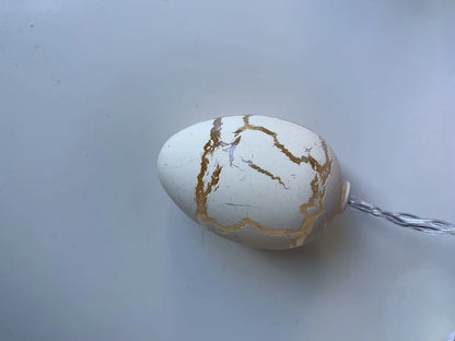 Crack egg LED string lights shaped around window with coloured plastic shells and flexible cable