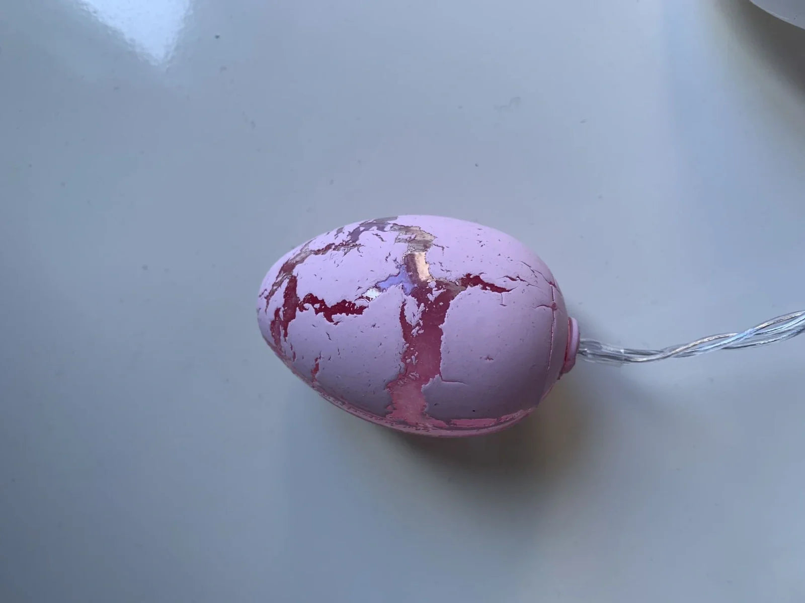 Crack egg LED string lights shaped around window with coloured plastic shells and flexible cable