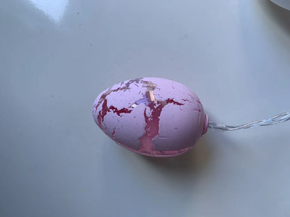 Crack egg LED string lights shaped around window with coloured plastic shells and flexible cable