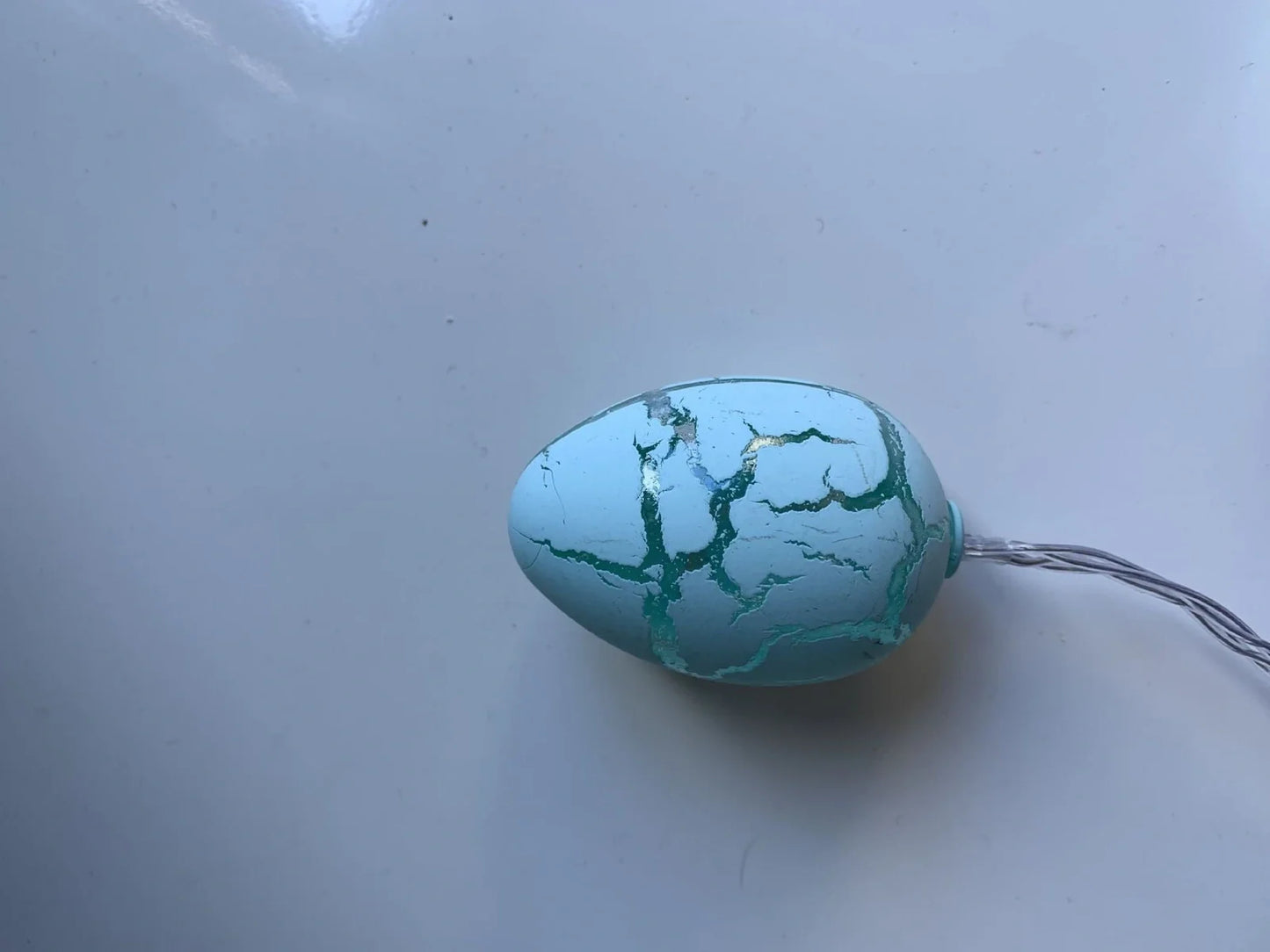 Crack egg LED string lights shaped around window with coloured plastic shells and flexible cable