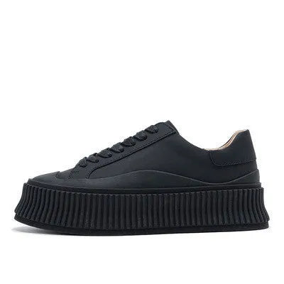 Women's black suede platform trainers with cross-strap binding and thick rubber soles