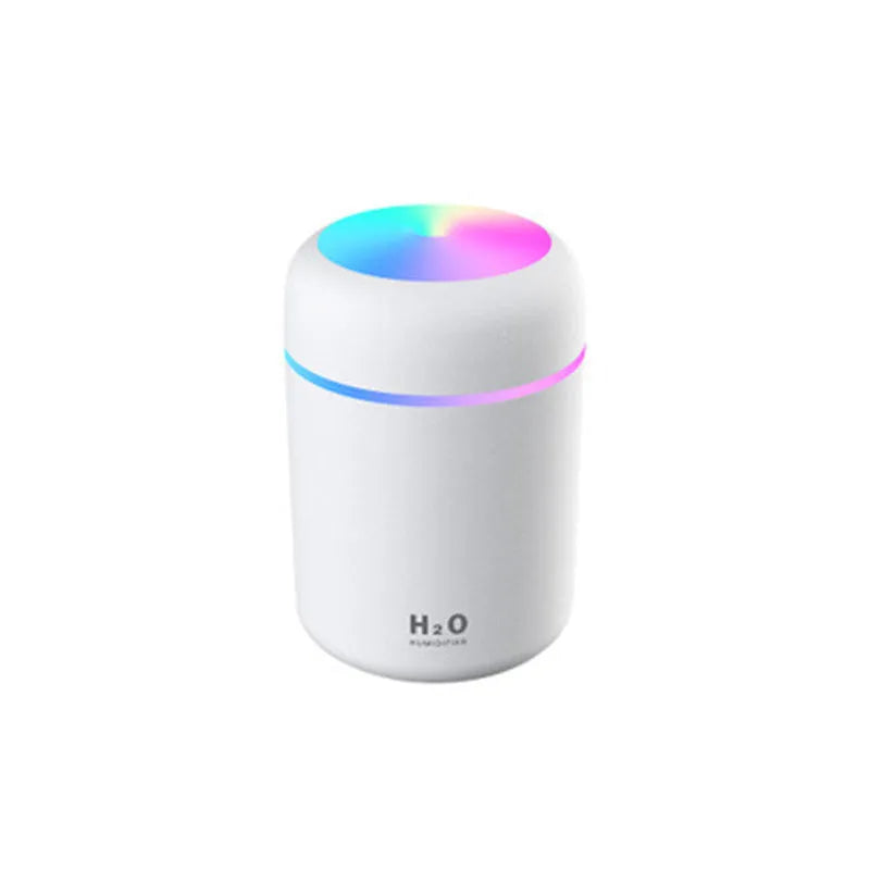 Pink car air purifying humidifier with LED lights on, next to a USB cable.