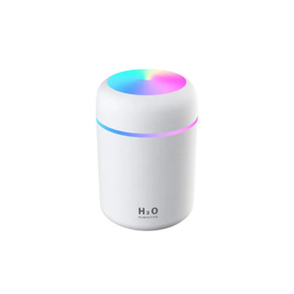 Pink car air purifying humidifier with LED lights on, next to a USB cable.