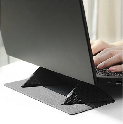 Blue or grey foldable laptop cooling stand with anti-slip surface on a desk.