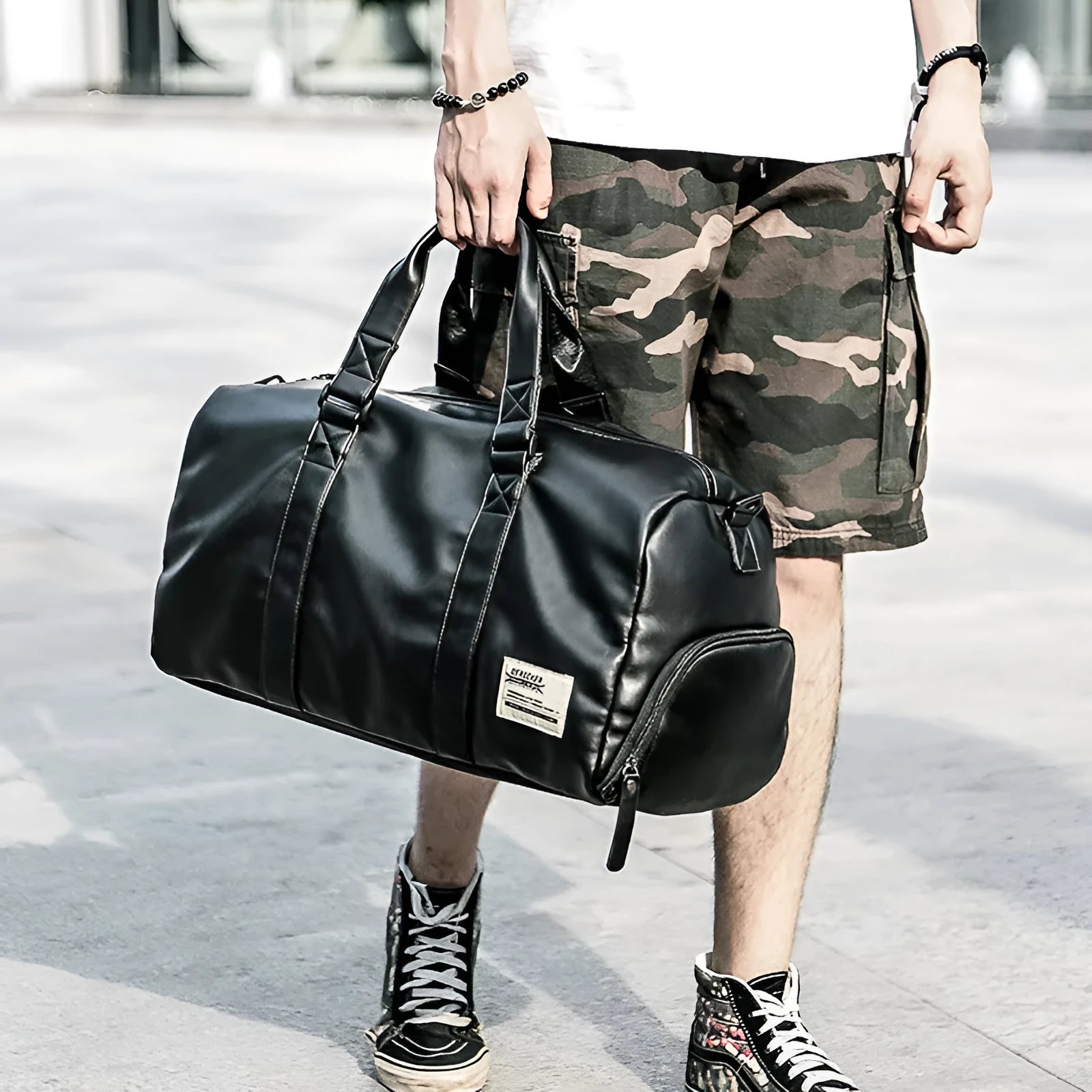 Black PU leather sports training bag with zipper pockets, showing 56-75 litre capacity and handle accessory