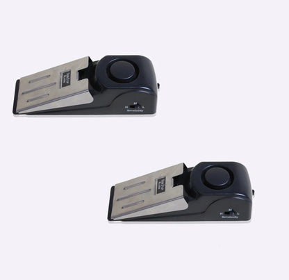 Portable wedge-shaped door stop alarm unit with stainless steel cover and sensitivity controls.