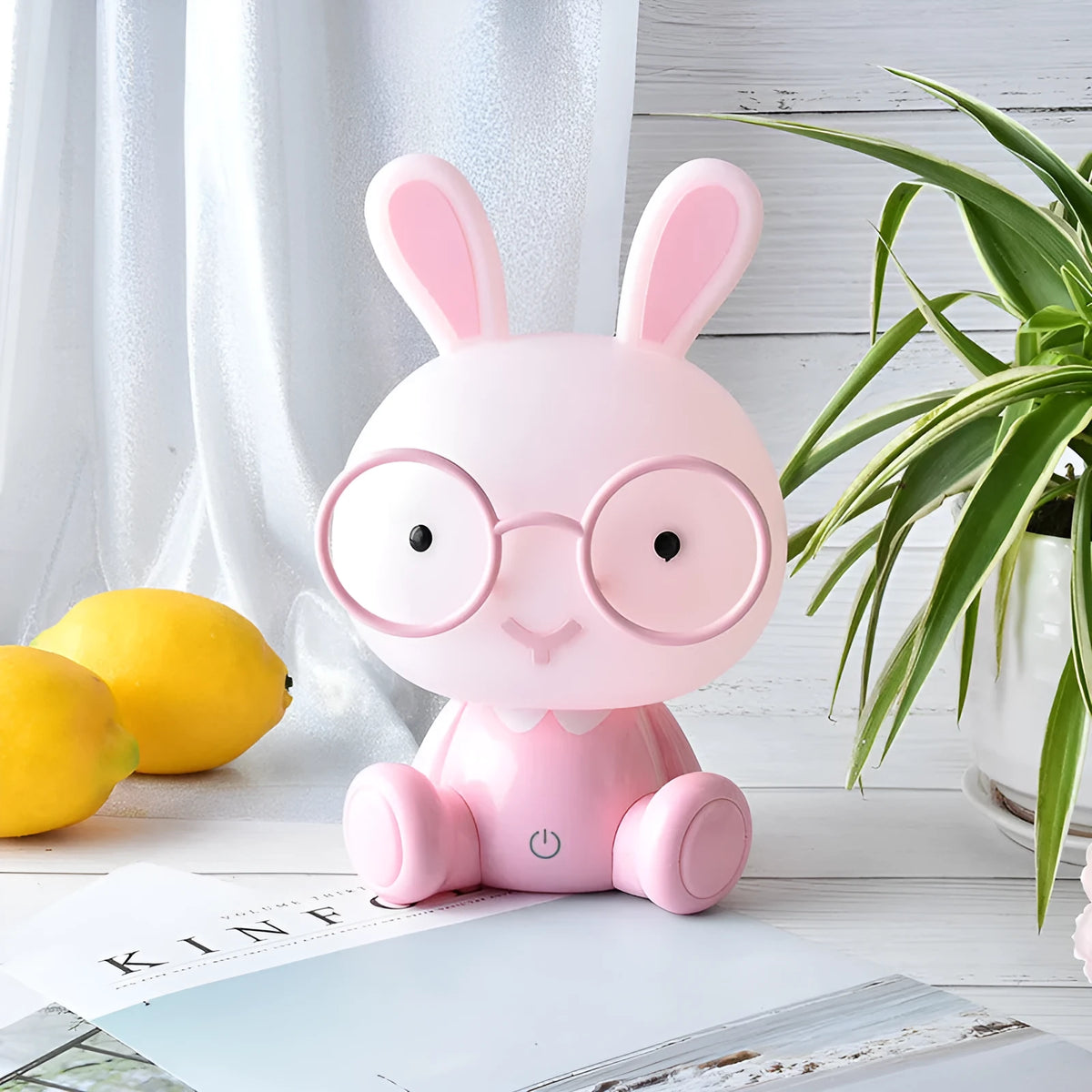 USB cartoon rabbit night light with glasses, in blue, green, or pink colour options on a table
