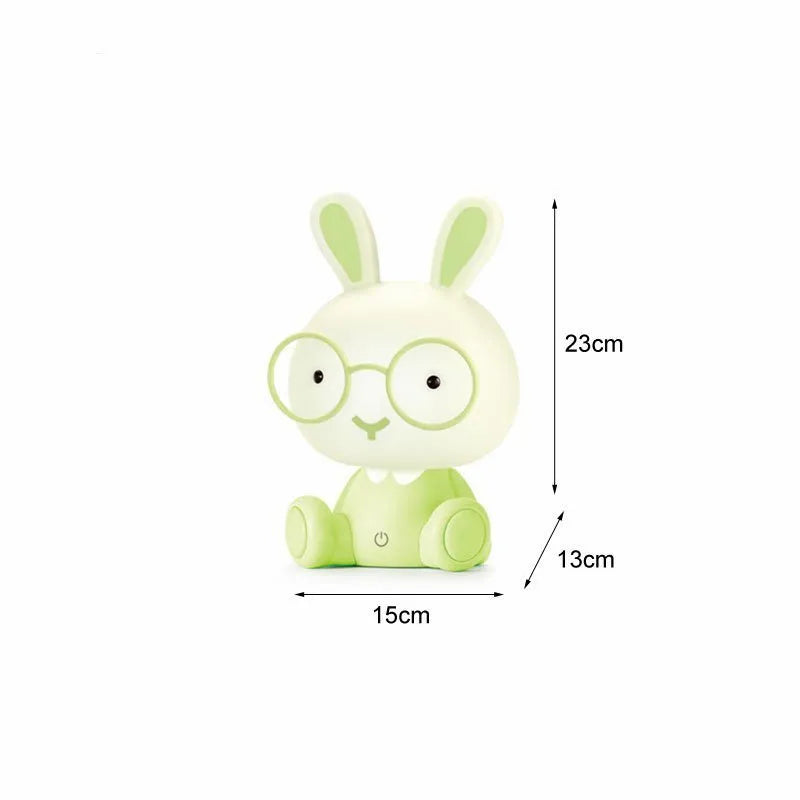 USB cartoon rabbit night light with glasses, in blue, green, or pink colour options on a table
