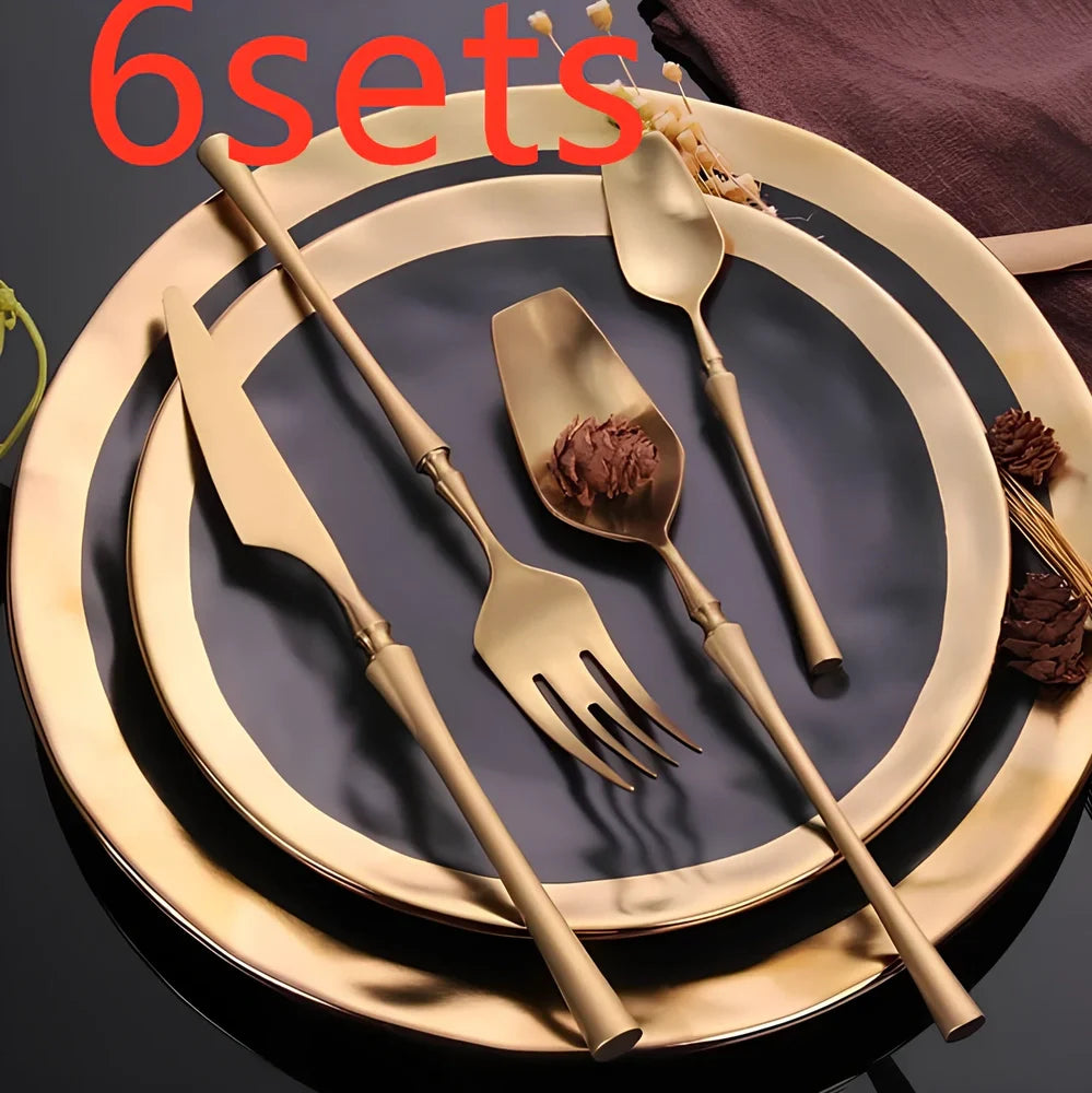 Four-piece stainless steel cutlery set showing main knife, fork, spoon, and teaspoon with mirror finish