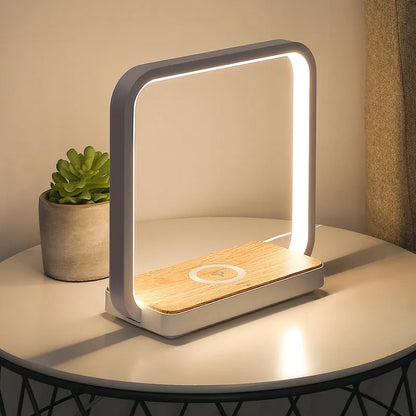 White aluminium bedside lamp with voice control and USB cable on wooden nightstand