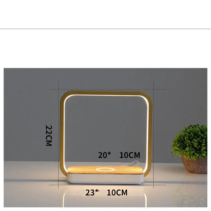White aluminium bedside lamp with voice control and USB cable on wooden nightstand