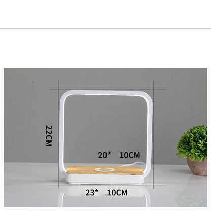White aluminium bedside lamp with voice control and USB cable on wooden nightstand