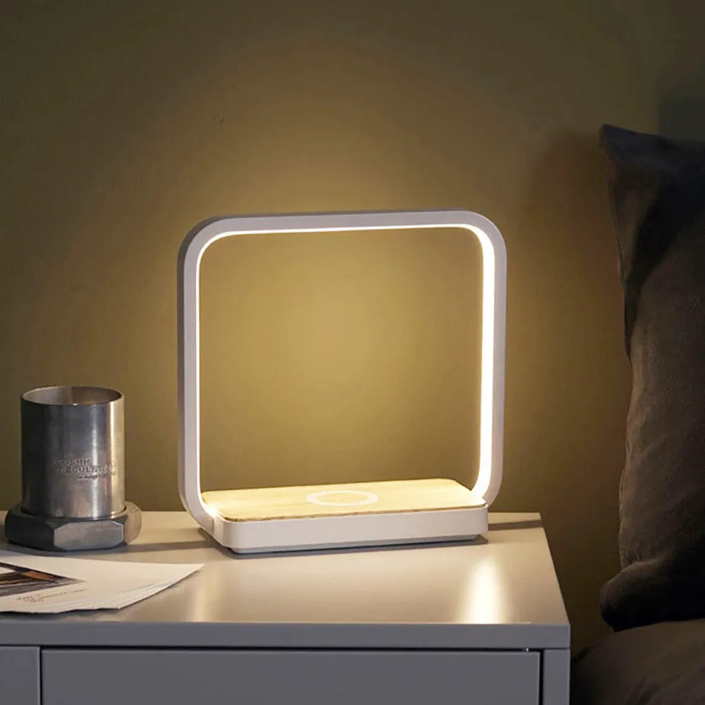 White aluminium bedside lamp with voice control and USB cable on wooden nightstand