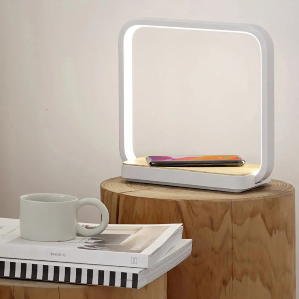 White aluminium bedside lamp with voice control and USB cable on wooden nightstand