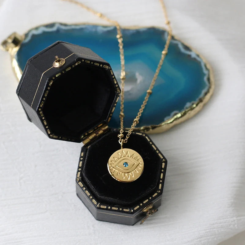 Mesmerizing blue-eyed gold coin pendant necklace with titanium steel chain and Seiko processing for premium quality and style