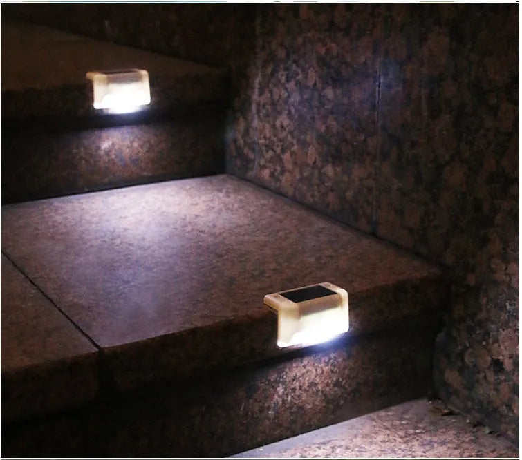 Set of four white rectangular solar-powered LED lights for outdoor railings and steps.