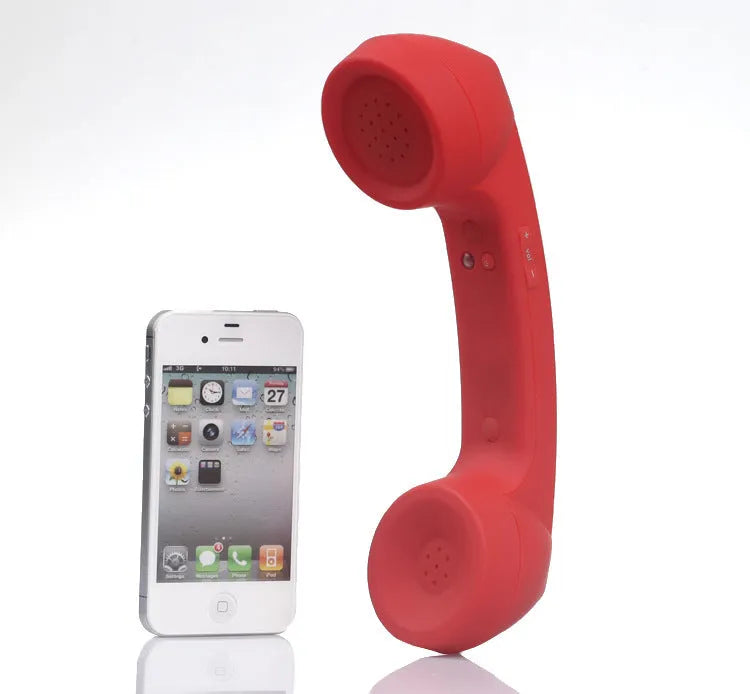 Retro-style Bluetooth wireless headset in hand, showing classic phone handset design and ear hook.