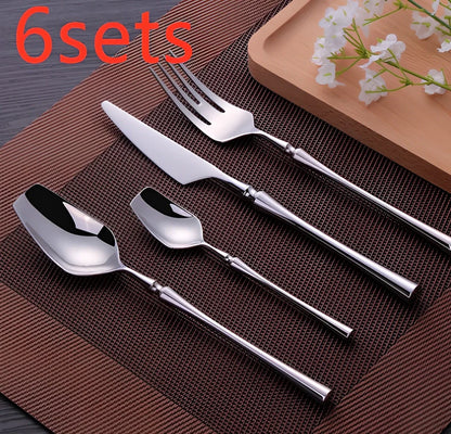 Four-piece stainless steel cutlery set showing main knife, fork, spoon, and teaspoon with mirror finish