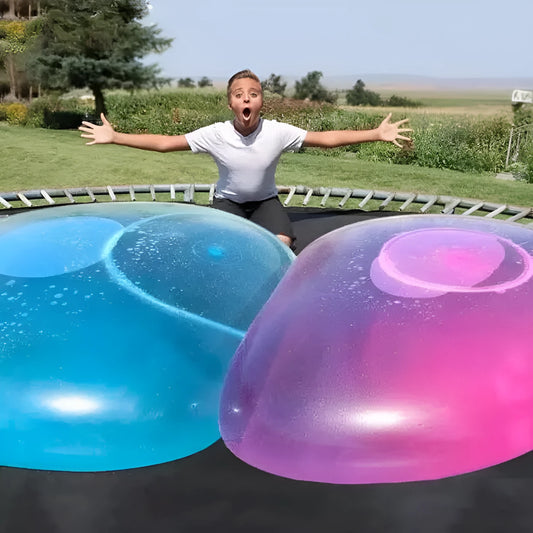Large pink, yellow, green, and blue inflatable bouncy balls in various sizes for children's play.