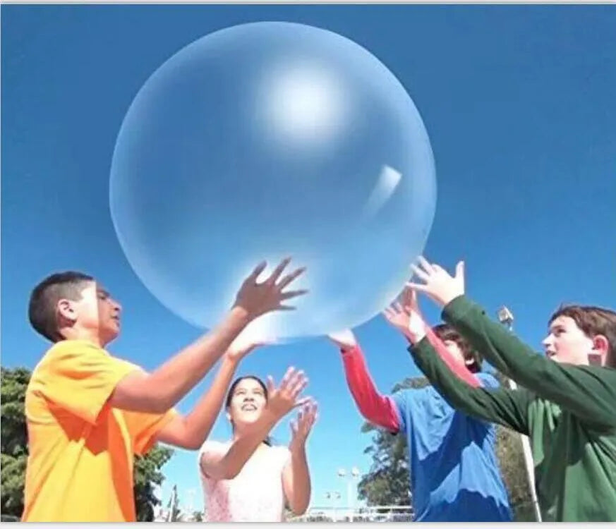 Large pink, yellow, green, and blue inflatable bouncy balls in various sizes for children's play.