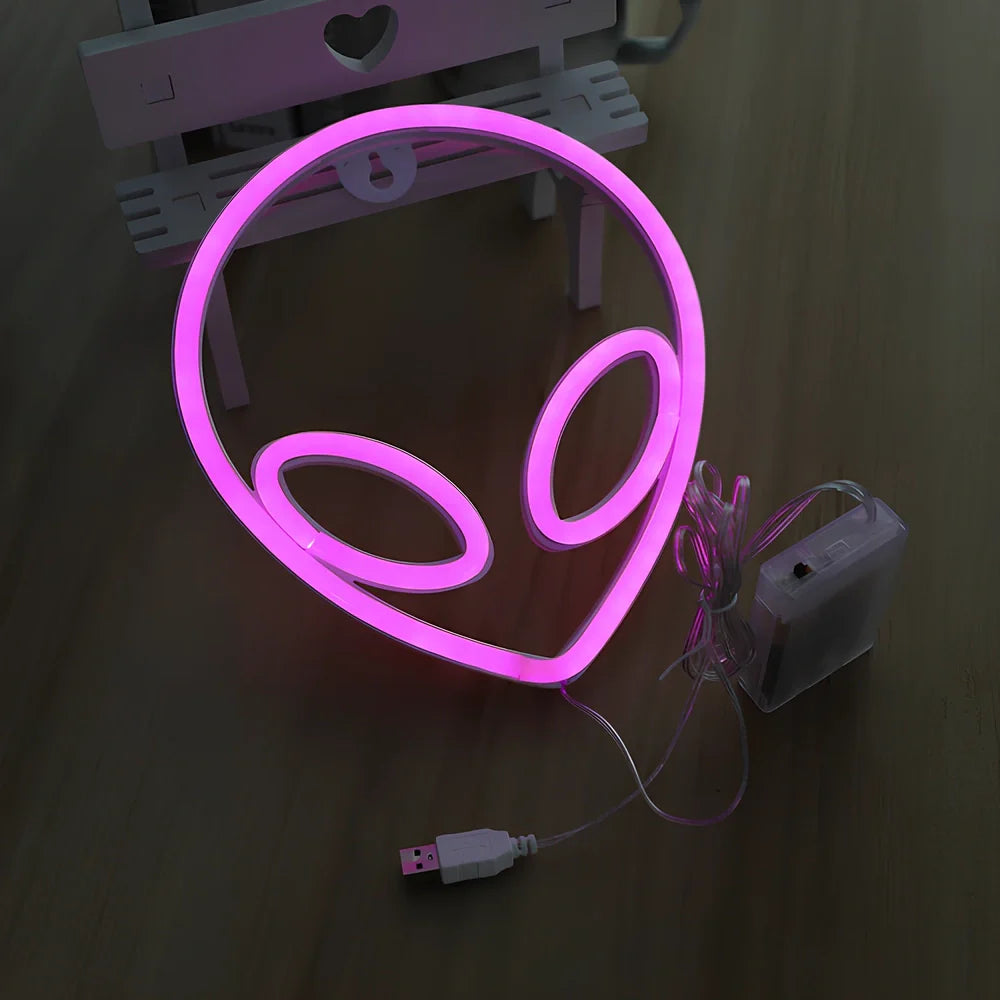 LED wall hanging neon modelling light with alien face design showing pink eyes and blue background illumination