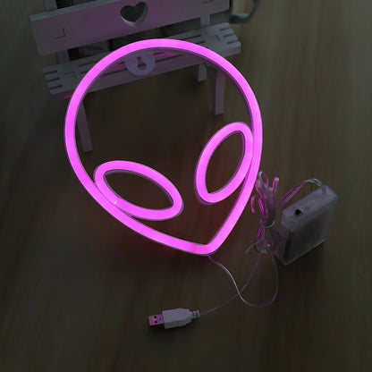 LED wall hanging neon modelling light with alien face design showing pink eyes and blue background illumination