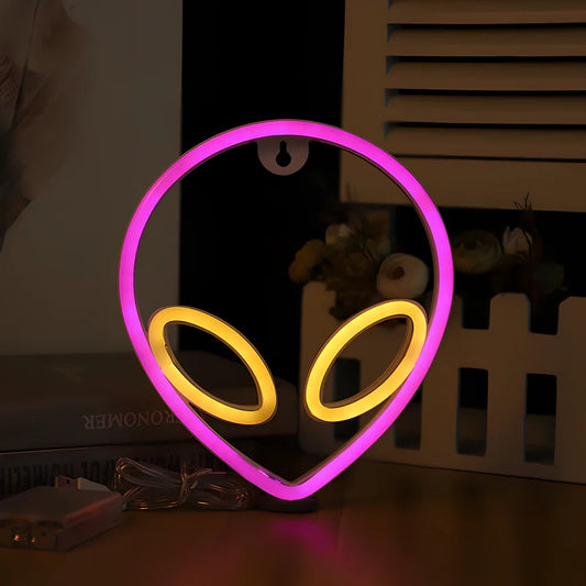 LED wall hanging neon modelling light with alien face design showing pink eyes and blue background illumination