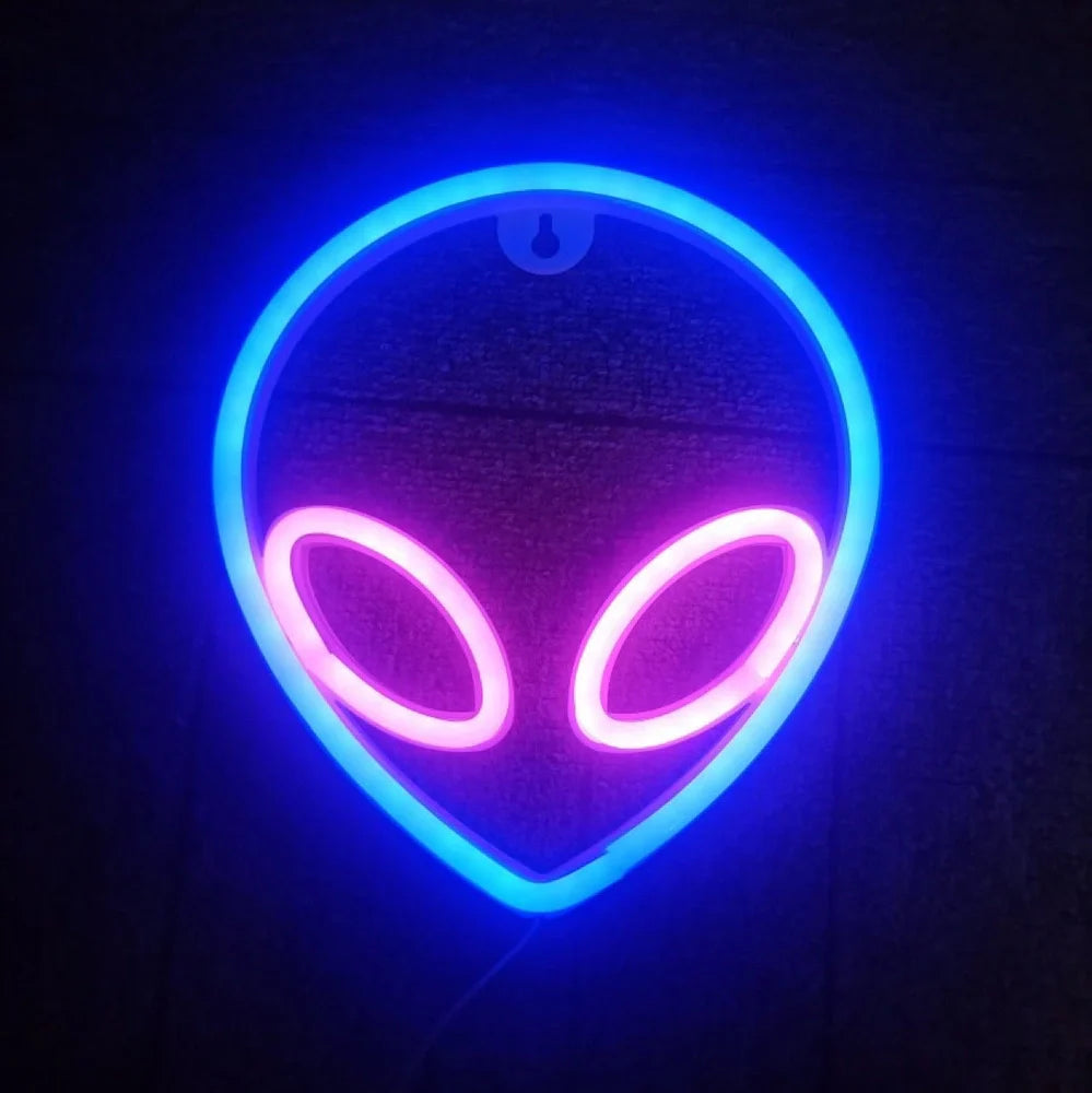 LED wall hanging neon modelling light with alien face design showing pink eyes and blue background illumination