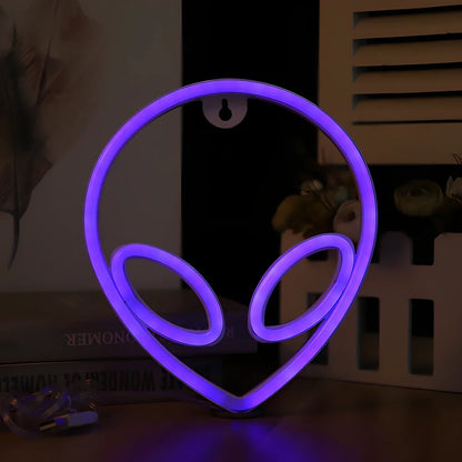 LED wall hanging neon modelling light with alien face design showing pink eyes and blue background illumination