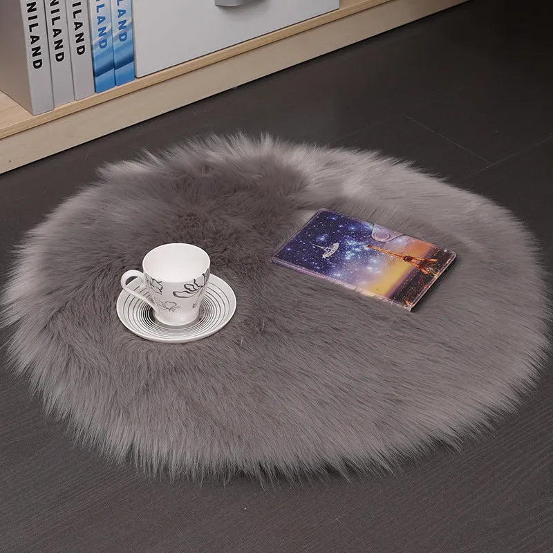 Round plush wool carpet in beige colour on a wooden floor.