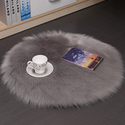 Round plush wool carpet in beige colour on a wooden floor.