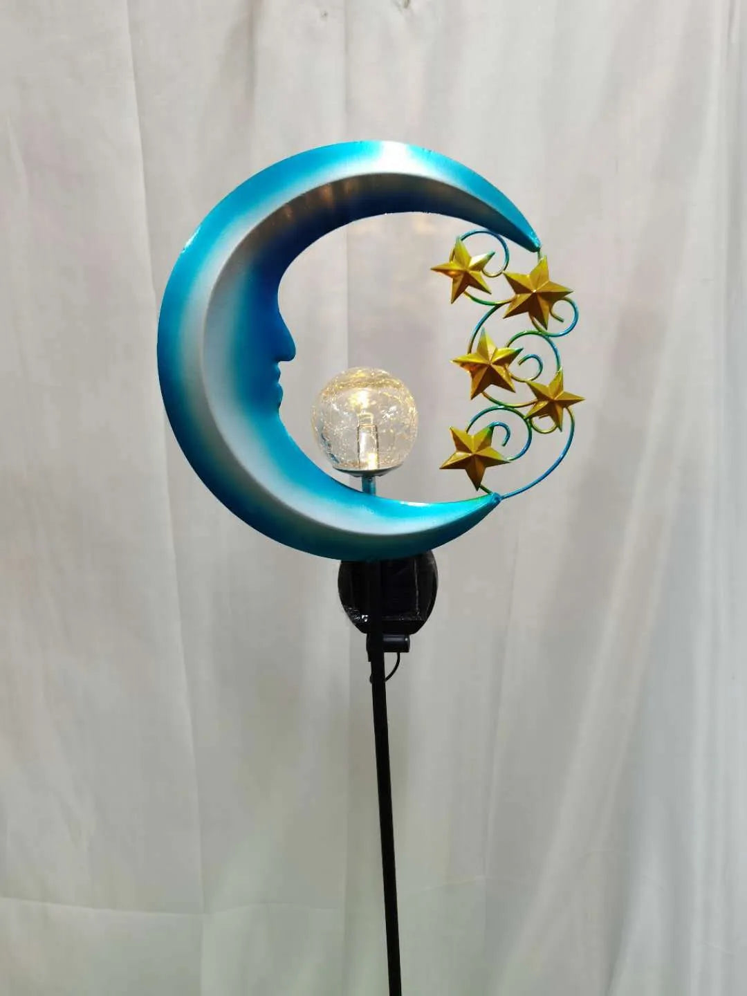Blue hollow moon-shaped solar garden light with wrought iron frame and crackled glass ball.