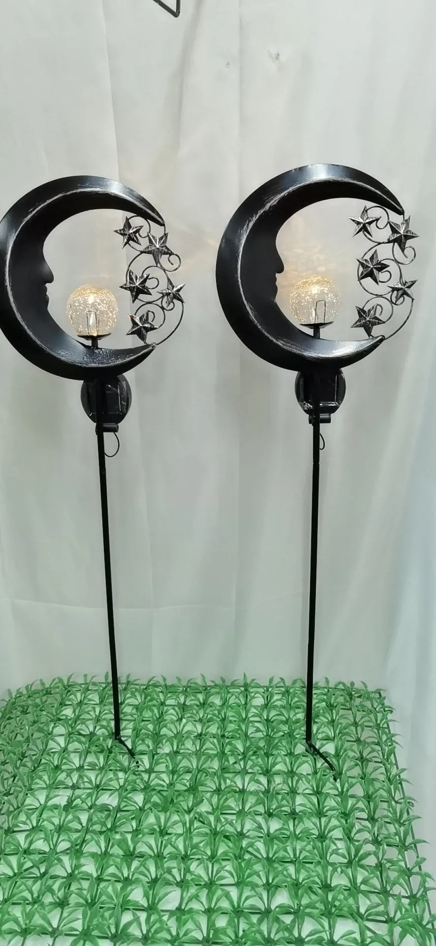 Blue hollow moon-shaped solar garden light with wrought iron frame and crackled glass ball.