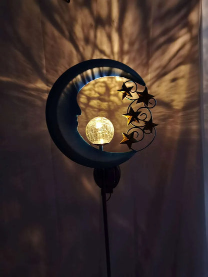 Blue hollow moon-shaped solar garden light with wrought iron frame and crackled glass ball.