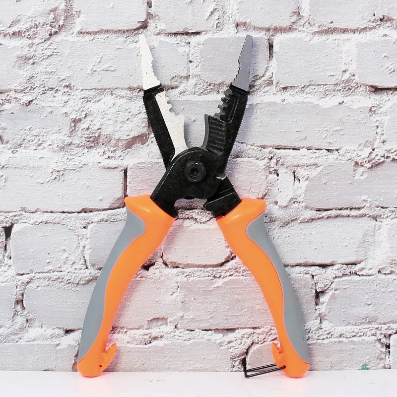 Orange multifunctional electrician's pliers and wire stripper with duckbill head on a workbench.