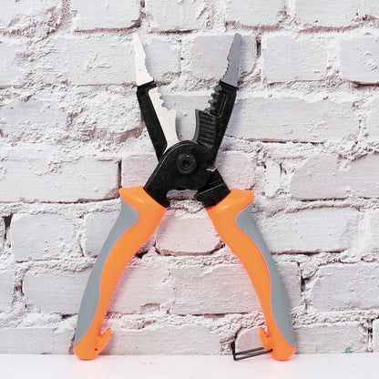 Orange multifunctional electrician's pliers and wire stripper with duckbill head on a workbench.