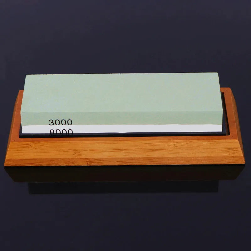 Green and white double-sided whetstone with bamboo base and sharpening accessories