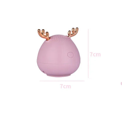 Small white, pink, or green portable Bluetooth speaker with USB cable.