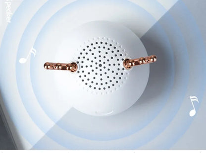 Small white, pink, or green portable Bluetooth speaker with USB cable.