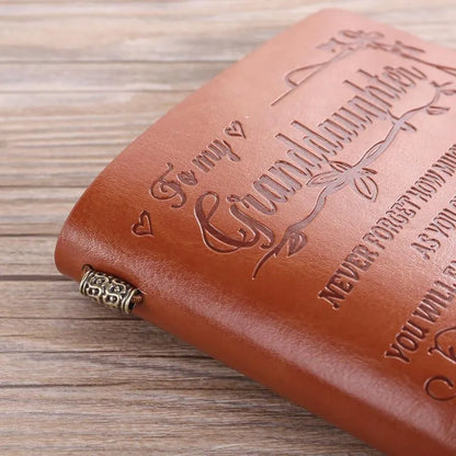 Leather cover business notebook with strap binding, open on warm brown acid-free paper.
