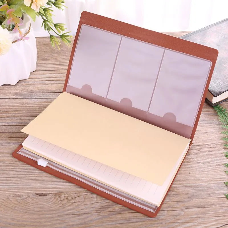 Leather cover business notebook with strap binding, open on warm brown acid-free paper.