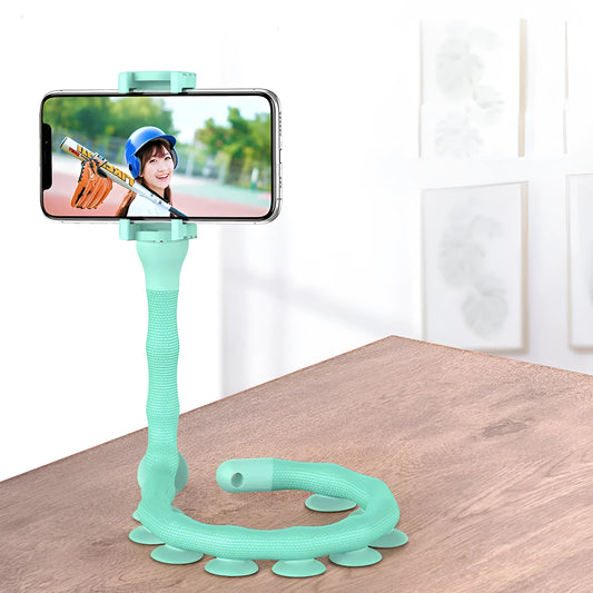 Black flexible gooseneck phone holder with suction cup mounted on a desk, holding a mobile phone at an angle.