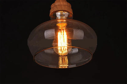 Glass single head pendant light with wood grain finish and adjustable cord.