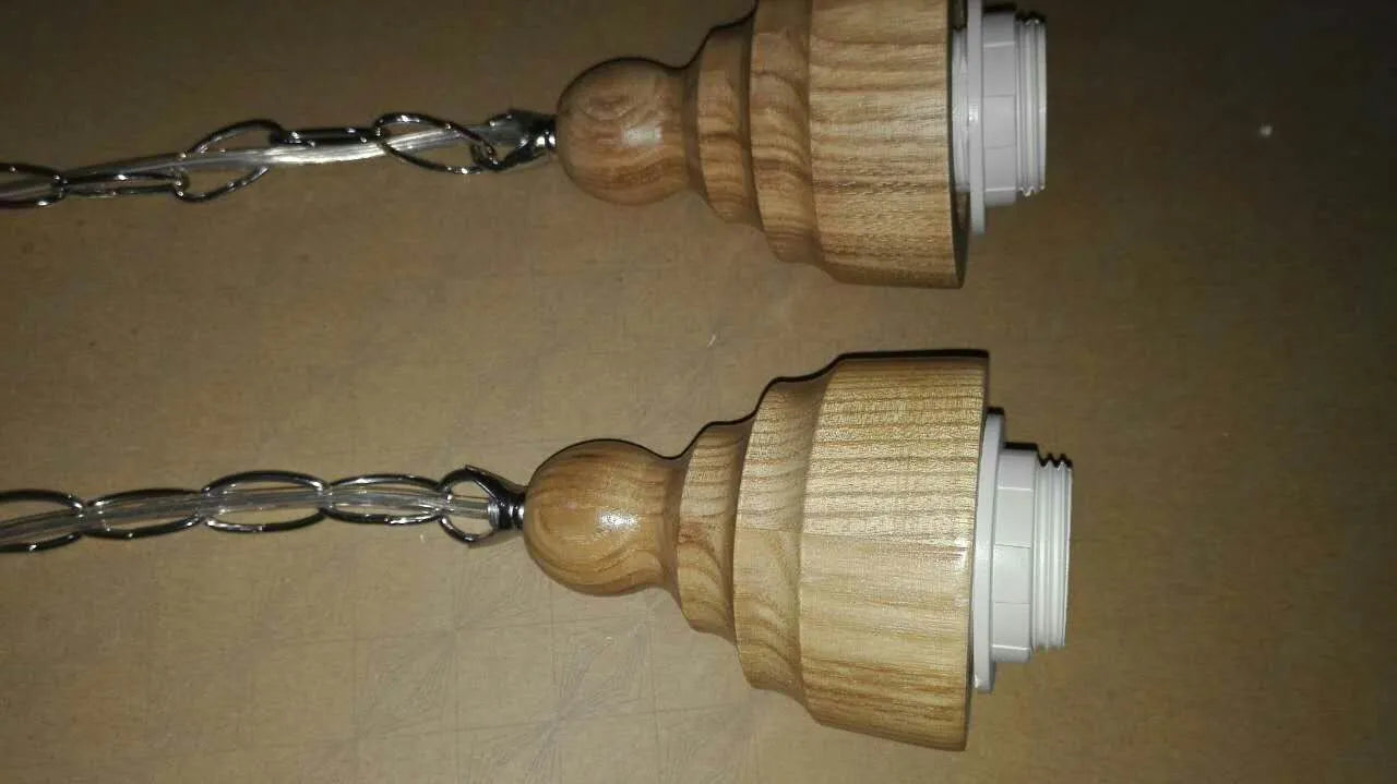 Glass single head pendant light with wood grain finish and adjustable cord.