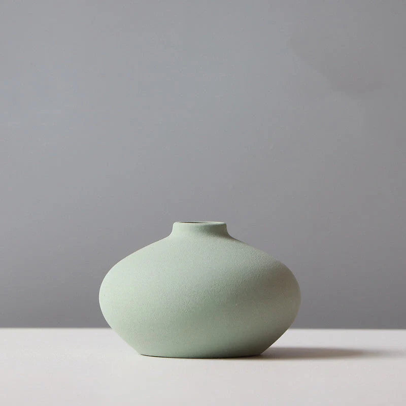 Stylish ceramic vases in various colors, including brown, black, green, and orange, for modern home decor
