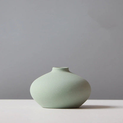 Stylish ceramic vases in various colors, including brown, black, green, and orange, for modern home decor